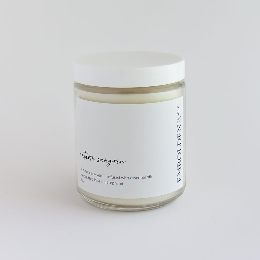 Hand-poured soy wax candle with a fruity autumn sangria scent in a clear glass jar.