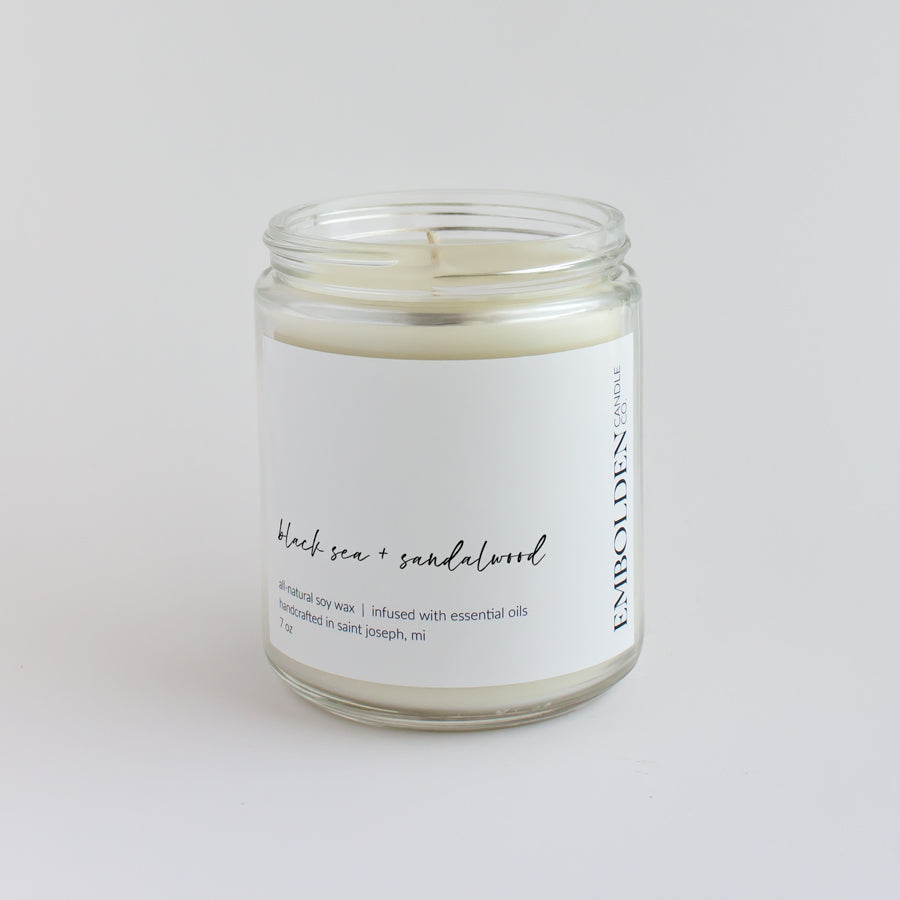 'Black Sea and Sandalwood' scented candle in a clear jar, offering a soothing coastal experience.
